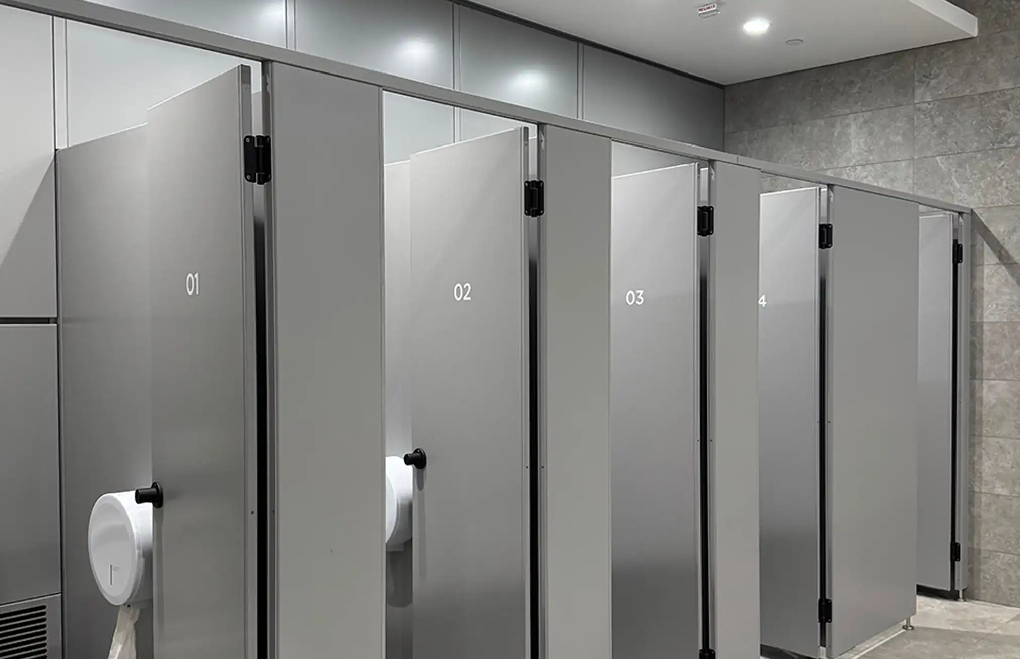 Moderner WC-Bereich mit eleganten Trennwänden und Waschtisch